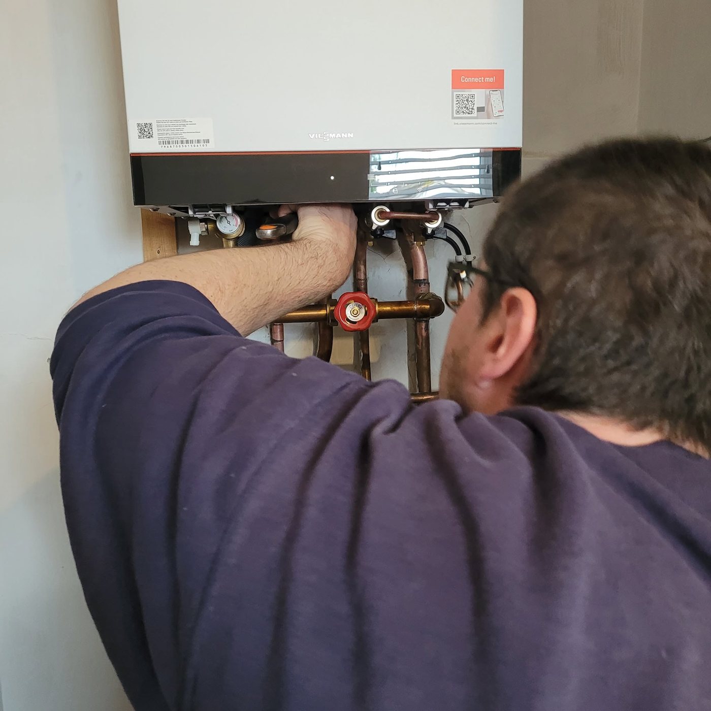 Engineer working on the pipework under a Viessmann boiler